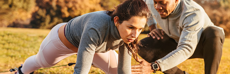 Woman stretching with man assisting