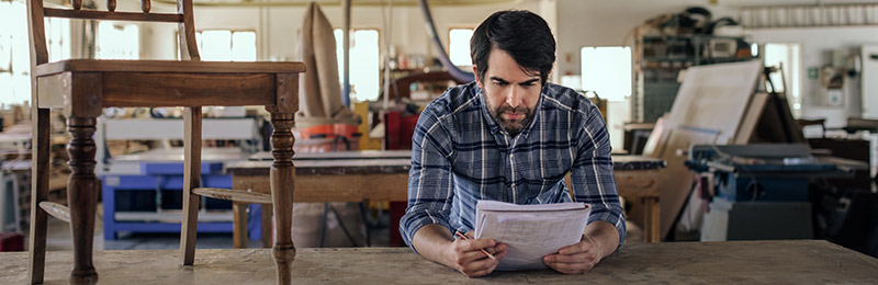 Man in furniture shop looking at notebook