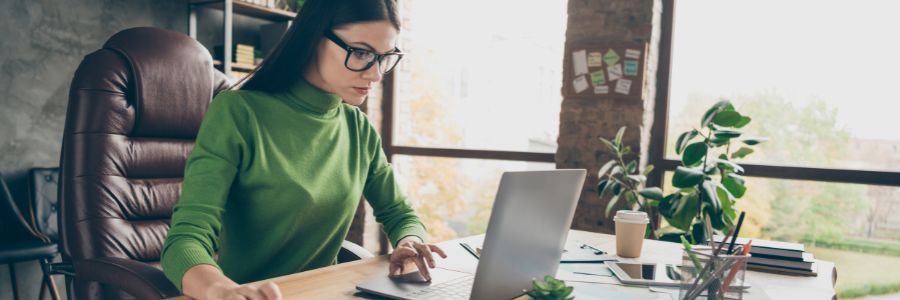 Female entrepreneur working in her home office on cloud accounting software and exploring her financials.